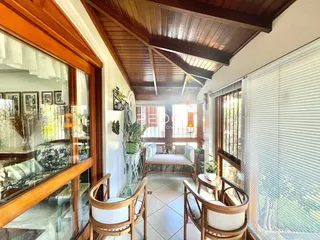 Sala de estar com teto de madeira e janelas amplas em Lajeado.