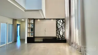 Sala de estar com paredes claras e grandes janelas.