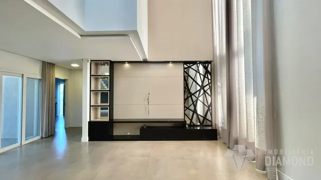 Sala de estar com paredes claras e grandes janelas.
