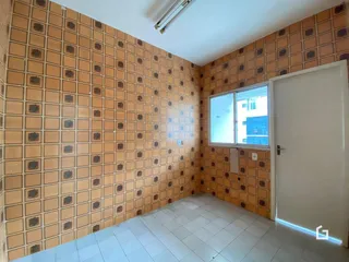 Parede interna com revestimento de azulejos alaranjados e piso branco em um imóvel.