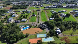 Vista aérea de uma propriedade com áreas verdes, piscina e quadras esportivas em Lajeado.