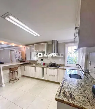 Cozinha com armários brancos e bancada de granito em um imóvel no Brasil.