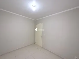 Interior de um cômodo com paredes brancas e piso de cerâmica.