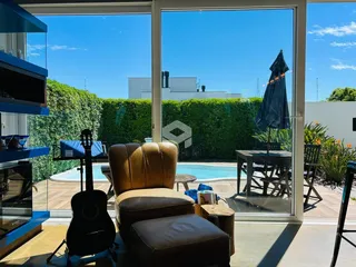 Sala com vista para a piscina e jardim lateral.