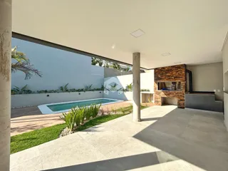 Vista de uma área externa com piscina e jardim de uma residência em Lajeado.