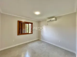 Ambiente interno de uma sala com piso claro e parede branca.
