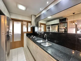 Foto de uma cozinha moderna com armários de madeira e bancadas escuras.