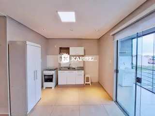 Uma cozinha moderna com armários brancos e piso claro é apresentada na propriedade.