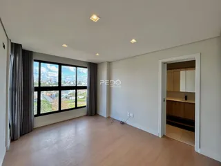 Sala de estar com grandes janelas que oferecem vista para a paisagem urbana.