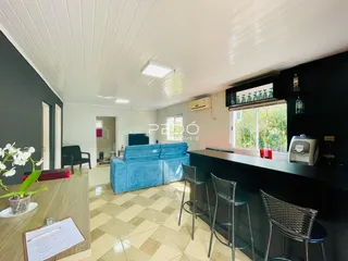 Sala de estar com sofá azul e piso de cerâmica clara.