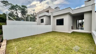 Vista da fachada de uma residência moderna com jardim gramado.