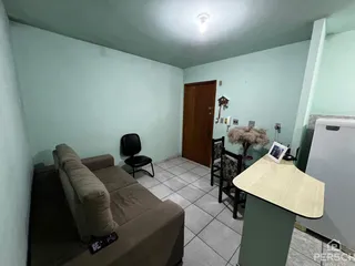 Sala de estar com sofá e piso de cerâmica em um apartamento.
