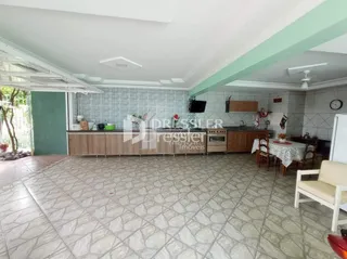 A sala apresenta um piso de cerâmica e armários de madeira na área interna.