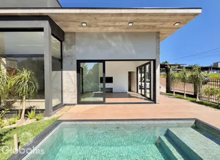 Fachada de uma residência com piscina e área externa.