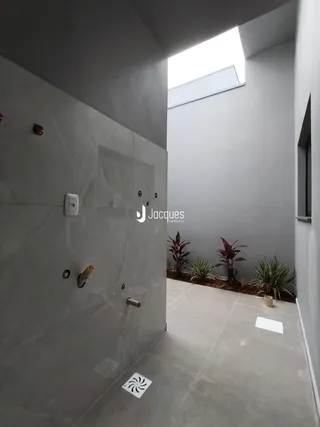 Vista de um corredor interno com paredes cinzas e piso claro.