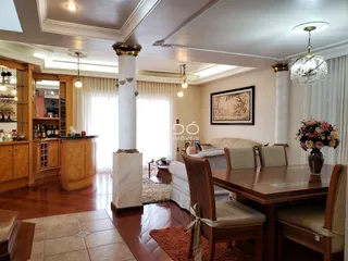 Sala de estar e jantar com piso de madeira e coluna decorativa.