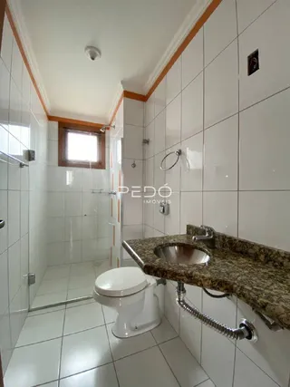 Foto de um banheiro com revestimento cerâmico branco.