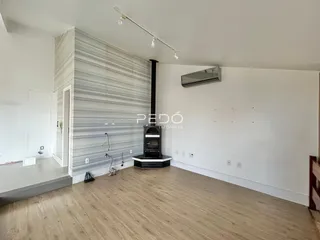 Sala de estar com piso de madeira e parede decorada em um imóvel no Brasil.