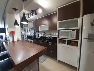 Imagem de uma cozinha com armários de madeira escura e mesa de jantar.