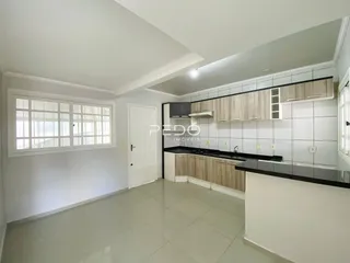 Ambiente interno de uma sala de estar com cozinha moderna em Lajeado.