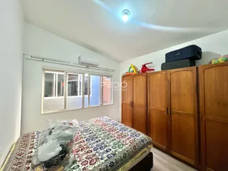 Quarto com cama e armários de madeira em um imóvel no Brasil.