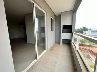 Vista de um ambiente interno com acesso a uma área externa através de uma porta de vidro.