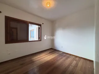 Sala de estar com piso de madeira e janela.