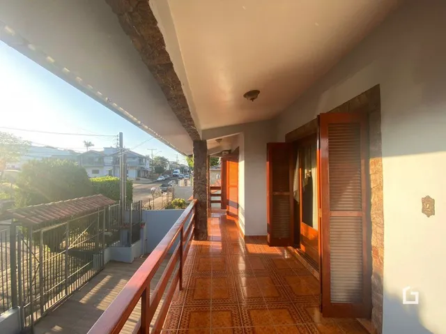 Corredor com piso de cerâmica de terracota que leva a uma área externa.