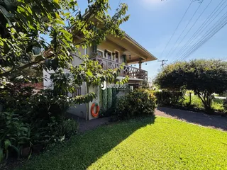 Fachada de uma casa em Lajeado, Brasil, com vegetação densa na frente.