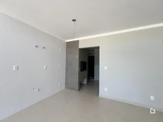 Vista interna de um ambiente com paredes brancas e piso claro.