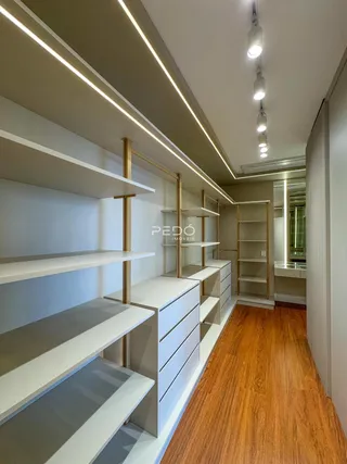 Hall de corredor com prateleiras e estantes em madeira e metal.
