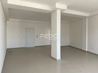 Imagem de um espaço interno com paredes brancas e piso claro.