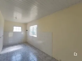 Interior de uma sala com piso de cerâmica e teto de painéis brancos.