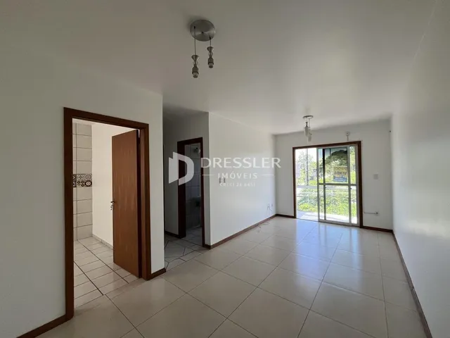 Vista de um corredor interno com portas de madeira em uma residência.