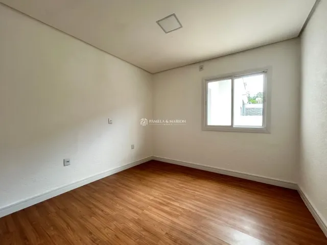 Foto de um cômodo interno com piso de madeira e janela.