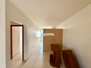 Hall de entrada com piso claro e assentos de destaque em um corredor interno.