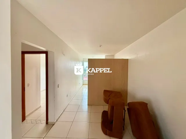 Hall de entrada com piso claro e assentos de destaque em um corredor interno.