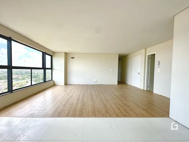 Sala ampla com grande janela e vista para a paisagem.