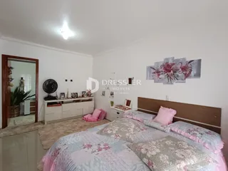 Quarto com cama e cabeceira de madeira em um imóvel.