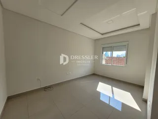 Ambiente interno de uma sala com piso de cerâmica e paredes brancas.