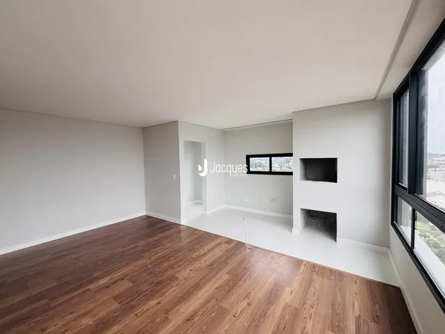 Ambiente interno de uma sala com piso de madeira e paredes brancas.