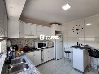 Cozinha moderna com armários brancos e bancada de granito.
