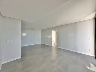 Ambiente interno amplo com piso de concreto e paredes brancas.
