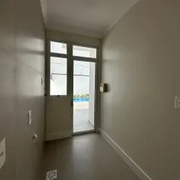 Foto de um corredor interno com paredes claras.