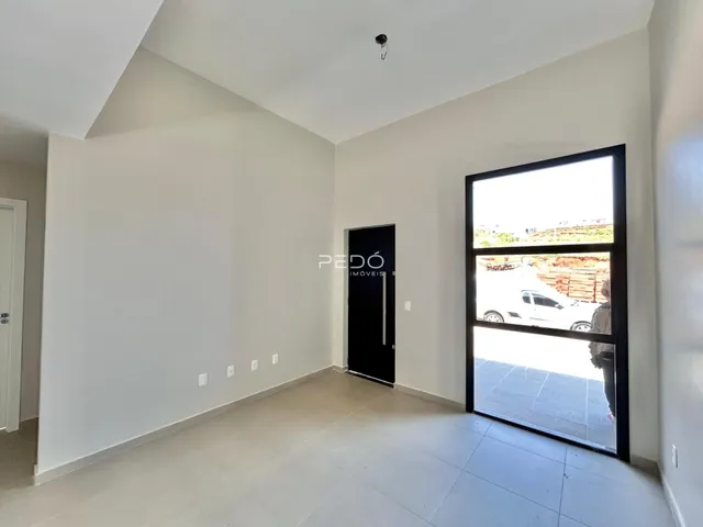 Interior de uma sala com paredes brancas e piso claro.