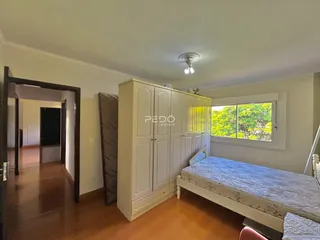 Quarto com guarda-roupa e janela com vista para a vegetação externa.