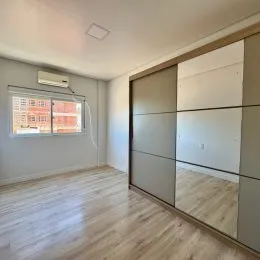 Sala de estar com piso de madeira e ar-condicionado visível.
