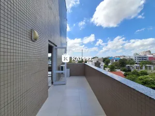 Fachada de um prédio moderno com piso claro e vista para o céu.