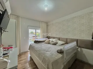 Quarto com cama grande e cortinas em um imóvel no Brasil.