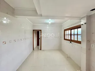 Corredor interno com paredes brancas e piso claro.